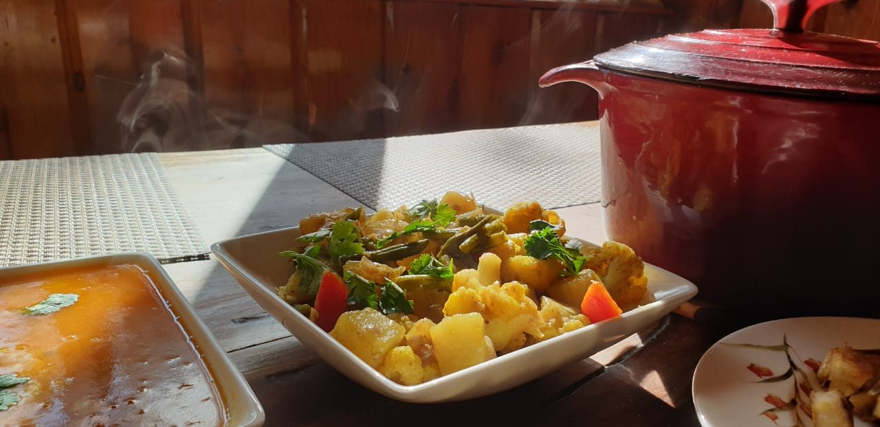 Steaming dishes and a red pot laid out on the dining table